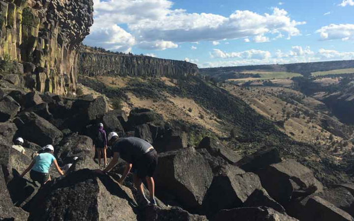 students make their way to a rock wall for climbing